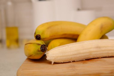 Olgun sarı muz, soyulmuş muz, mutfak masasında olgun muz dilimleri.