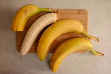 Olgun sarı muz, soyulmuş muz, mutfak masasında olgun muz dilimleri.