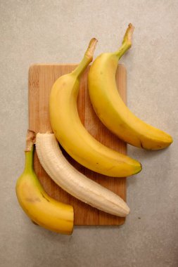 Olgun sarı muz, soyulmuş muz, mutfak masasında olgun muz dilimleri.