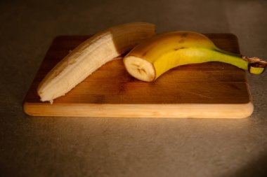 Olgun sarı muz, soyulmuş muz, mutfak masasında olgun muz dilimleri.