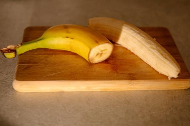 Olgun sarı muz, soyulmuş muz, mutfak masasında olgun muz dilimleri.