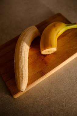 Olgun sarı muz, soyulmuş muz, mutfak masasında olgun muz dilimleri.