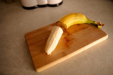 Olgun sarı muz, soyulmuş muz, mutfak masasında olgun muz dilimleri.