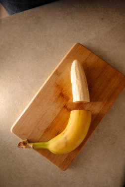 Olgun sarı muz, soyulmuş muz, mutfak masasında olgun muz dilimleri.