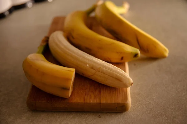 Ripe yellow banana, peeled banana, slices of ripe banana on the kitchen table