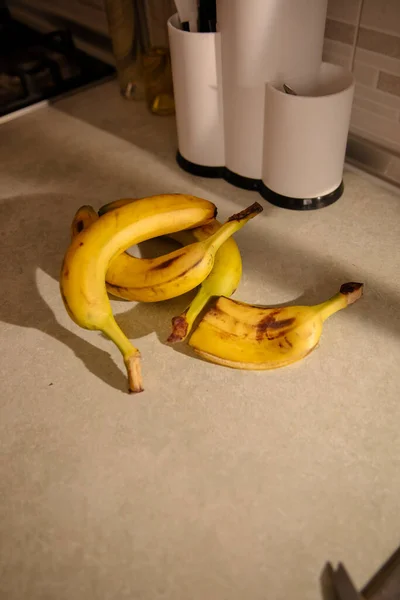 Ripe yellow banana, peeled banana, slices of ripe banana on the kitchen table