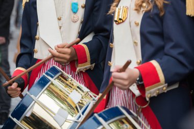 Tanınmayan insanlar davullarını tahta sopalarla çalıyorlar. Geleneksel kıyafetler.