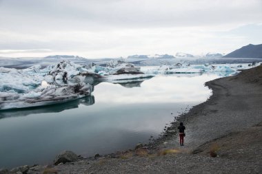 Sırtından Jokulsarlon buzulunda resim çekerken görülen bir kadın. İzlanda