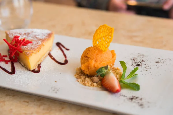 Delicius dessert for sharing. Cheese cake and orange ice cream. Portugal