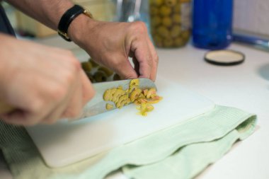 Erkek eli zeytin kesiyor. Japon bıçağı. Mutfak.