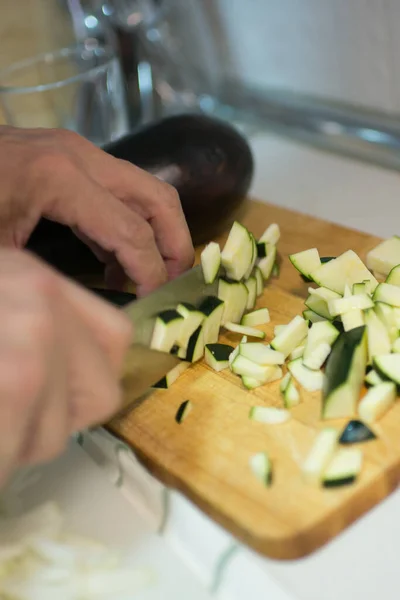 stock image Human hands cutting zucchini into pieces. Interior