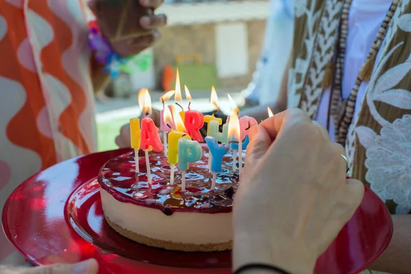 Kaukasische Hände Zünden Kerzen Auf Einer Geburtstagstorte Käsekuchen Mit Erdbeermarmelade — Stockfoto