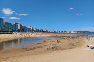 San Lorenzo sahilindeki Piles Nehri manzarası ve Gijon, Asturias 'taki sahil şeridi. Güneşli bir gün, önemsiz insanlar