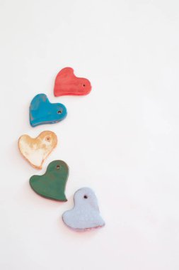 Aşk ve çeşitlilik. Renkli kalp şekilli seramik parçalar. Beyaz arkaplan
