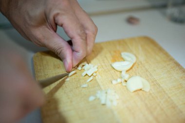 İnsan eli sarımsak dişlerini küçük parçalara ayırıyor. İç mekan