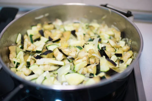 Cooking pan heating diced vegetables. Domestic kitchen