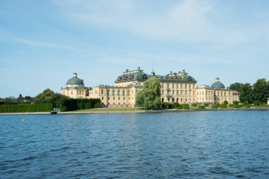 View of Drottningholm palace aproaching by ship. Stockholm, Sweden. It is the permanent home residence of Their Majesties the King and Queen of Sweden.  clipart