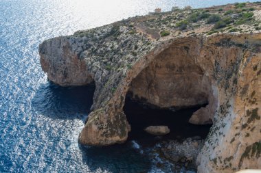 Blue Grotto, Malta, Avrupa 'da. Turistik tekneler kayadaki doğal kemer penceresinin altından geçiyor.
