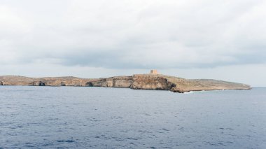 Saint Mary kulesiyle birlikte Comino sahilinde. Malta. Malta 'nın Comino adasında büyük bir gözetleme kulesi. 1618 'de inşa edildi, altı Wignacourt kulelerinin beşincisi..