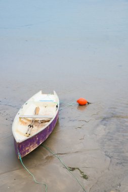 Kumsalda turuncu bir şamandıraya yakın bir leyla teknesi. Cantabrian kıyıları, İspanya