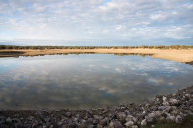 Göllü ve bulutlu güzel bir manzara. Güneşli bir günde gölde yansıyan bulutlar.