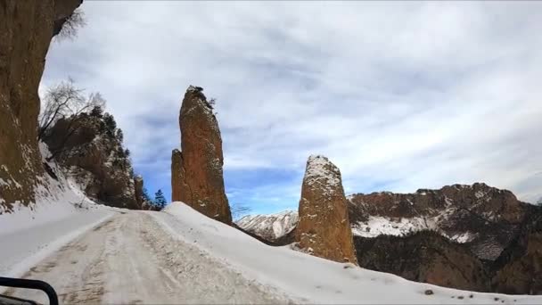 Car Drives Dangerous Snowy Road Winding Highland Stone Pillars Extreme — Wideo stockowe
