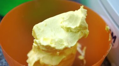 Mutfakta turuncu plastik kasede biraz tereyağı var. Hamur malzemesi. Yüksek kalite pişirmek için doğal gıda ürünü.