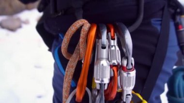 İp ve güvenlik ekipmanlarıyla tırmanışçı dev kayaların yanında tırmanışa hazırlanıyor. Kafkasya dağlarında faaliyete hazır bir adam var.