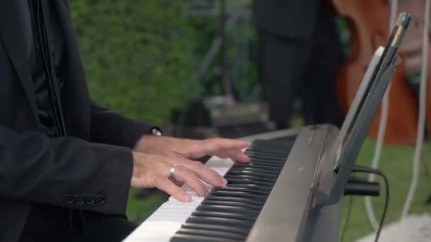 钢琴师在露天婚礼上为合成器演奏旋律 邀请专业音乐家在豪华婚宴上演唱歌曲 — 图库视频影像
