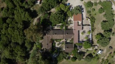 Kır spa kompleksi ziyaretçileri vücut tedavisi için bekliyor. Arabalar park yerinde sahiplerini bekler. Banliyö binası yeşil ağaçların arasında duruyor.
