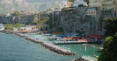 Körfez parlak güneşle aydınlandı ve İtalya 'da deniz tarafından yıkandı. Turistler dalgalarda güneş yanığı olur. Antik Sorrento şehrinde dağın eteklerinde resim gibi binalar var.