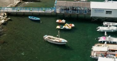 Güney İtalya 'nın denizini ve doğasını keşfeden turistler için modern tekneler. Tekneler ve yatlar Sorrento 'daki deniz kıyısının yakınındaki masmavi körfez yüzeyinde sürükleniyor.