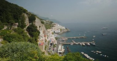 Güney İtalya 'da turistler için demirli tekneleri ve gemileri olan körfez. Deniz suyu, Amalfi 'nin yuvalanmış eski evleri ile dağların eteklerini siler.