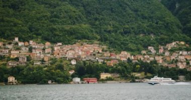 İtalyan ormanlarının eteklerine dağılmış antik evler. Büyük turizm gemisi güney İtalya dağlarında küçük bir yerleşim yerinden geçiyor