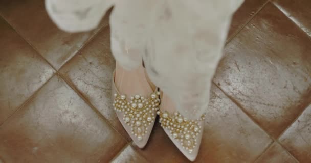 在意大利南部 镶有珍珠珠子的贵重鞋子从婚纱下透出 参加隆重的婚礼 筹备在酒店房间举行的婚礼 — 图库视频影像