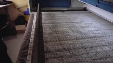 Üretim atölyesindeki kumaş kesme makinesinin boş çalışma yüzeyi. Giysi yapımı fabrika ekipmanları. Otomatik üretim teknolojisi