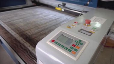 Atölye kapanışında renkli düğmeleri olan otomatik kumaş kesme makinesi. Çağdaş üretim teknolojisi