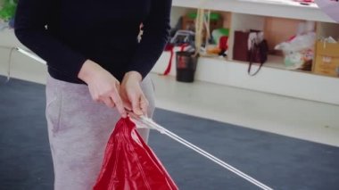 İşçi önlemleri, dikiş atölyesinde paraşütle atlamak için örülmüş bağcıkları birbirine bağlıyor. Master, ekstrem spor ekipmanları üretimini kontrol ediyor