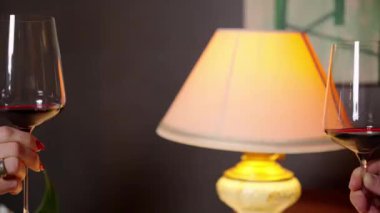 Kadın ve erkek, akşam kafeteryasında şarap bardaklarını birbirine vuruyor. Romantik ilişkinin yıldönümünü restoranda kutlayan çift.