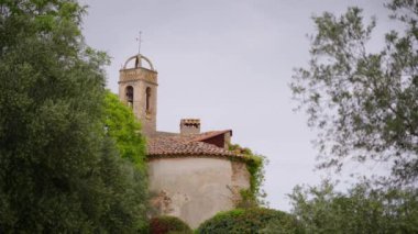 Castell d Emporda Otel kompleksi üzerinde çan kulesi ve çapraz eski kilise binası. Turistler için ortaçağ tarihi mimari mirası ilginç