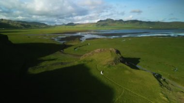 Yeni evliler çimenli tepe boyunca yürür büyüleyici hava manzarasının tadını çıkarırlar. İzlanda 'da hatırlanmaya değer fotoğraflar için birkaç arama yeri