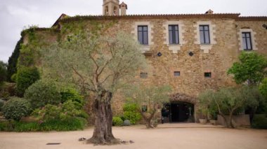 Castell d Emporda Oteli bahçe ve tarihi kemer kapılı misafirlerle tanışmaya hazır. Ortaçağ İspanyol kalesi lüks düğün yeri olarak ünlüdür.