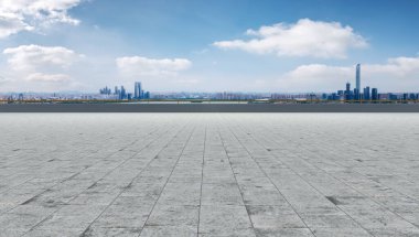 Boş tuğla zemin ve şehrin ufuk çizgisi arka planı