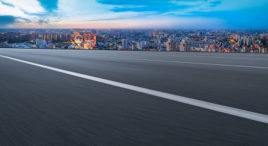 Panoramik ufuk çizgisi ve modern binalarla dolu boş asfalt yol