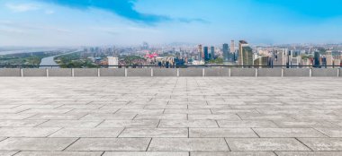 Boş tuğla zemin ve şehrin ufuk çizgisi arka planı