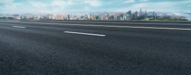 Panoramik ufuk çizgisi ve modern binalarla dolu boş asfalt yol