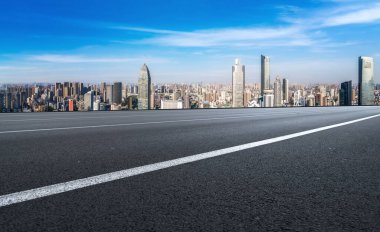 Panoramik ufuk çizgisi ve modern binalarla dolu boş asfalt yol