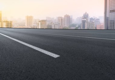 Panoramik ufuk çizgisi ve modern binalarla dolu boş asfalt yol