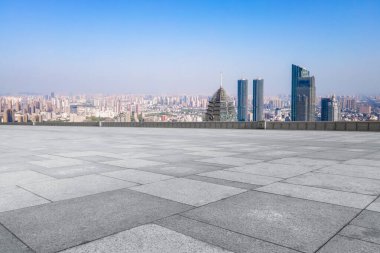 Boş tuğla zemin ve şehrin ufuk çizgisi arka planı