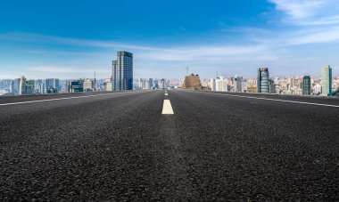Panoramik ufuk çizgisi ve modern binalarla dolu boş asfalt yol